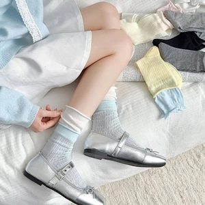 Détail de chaussettes montantes côtelées style ballet avec doubles revers à volants