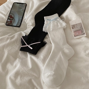 Détail de chaussettes Lolita avec dentelle et nœuds en ruban en blanc et noir chic