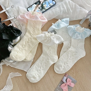 Détail macro de chaussettes Lolita blanches à motif de cœur ajouré et volants en satin
