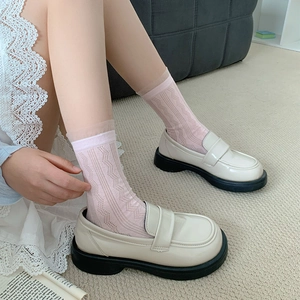Gros plan de chaussettes en jacquard rose avec mocassins plateforme blanc crème