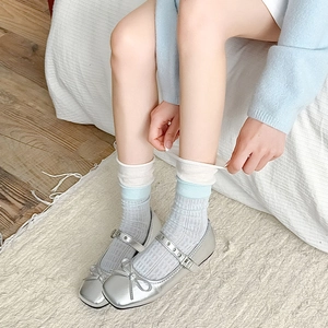 Ballerines Mary Jane argentées avec nœud et bout carré dans un décor intérieur douillet