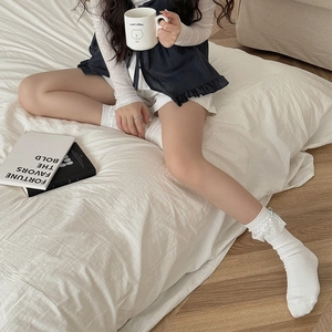 Gros plan de chaussettes Lolita blanches en dentelle avec petits nœuds bleu clair