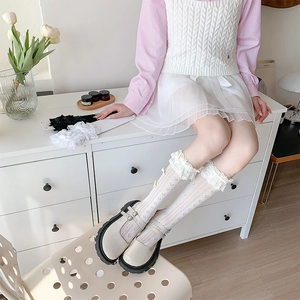 Detailed view of white lace trim heart pattern socks with off-white Mary Jane shoes