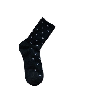 Sweet black crew socks with white heart pattern and ribbed cuffs on white background