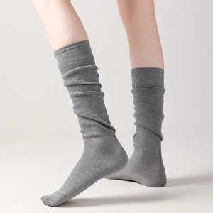 Detail of medium grey knit slouch socks with fine ribbed cuffs and textured cotton fabric