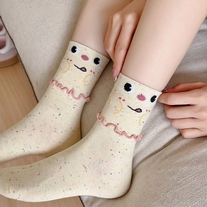 Cute cream mid-calf socks with colorful speckles, cartoon face, and pink ruffle edge