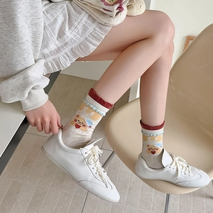 Detail of cute bear pattern and frilly ruffled cuffs on beige cotton crew socks