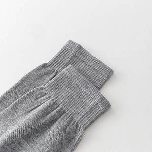 Detailed view of the ribbed knit cuff and soft grey fabric of the calf-high socks
