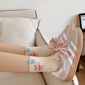 Close-up of pink bear print mid-calf socks paired with purple suede sneakers