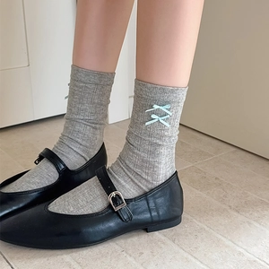 Detail of light gray ribbed socks with sweet light blue bows paired with Mary Janes