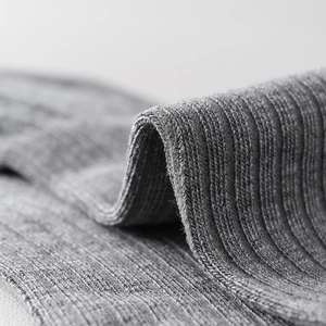 Close-up of grey ribbed knit texture showing the detailed vertical striped weave pattern