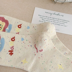 Detailed knit texture of cream mid-calf socks with rainbow dots and sunflower pattern