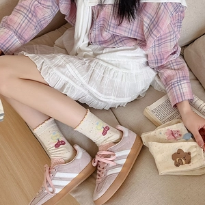 Detail of cute bear and balloon patterns on beige crew socks with wavy ruffled edges