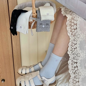Dettaglio della trama con fiocco su calze di cotone in vari colori pastello delicati