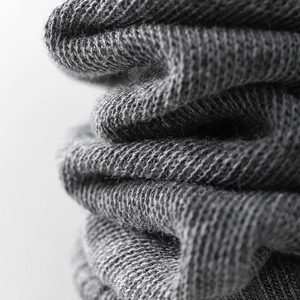 Macro shot of dark grey knitted fabric showing fine texture and soft fiber details