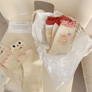 Detailed view of women's cotton socks with cute bear patterns and frilly pink cuffs