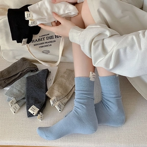 Détail de chaussettes en maille à côtes verticales avec étiquette décorative