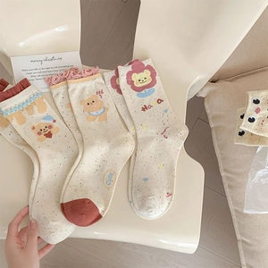 Close-up of ruffled cuff socks with cartoon bear embroidery and colorful flecked texture