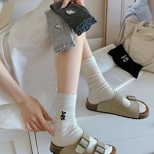 Detail of colorful rib knit cotton socks with cute cartoon embroidery and wavy cuffs
