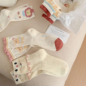 Detail of ruffled cuff socks with cute bear patterns and colorful flecked knit fabric