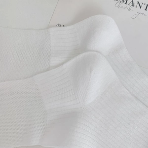 Nahaufnahme weißer gerippter Ballettsocken in Kniehöhe mit feiner Stoffstruktur