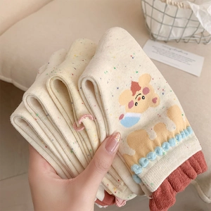 Close-up of cream knit socks with colorful speckles and cute cartoon bear patterns
