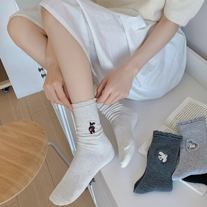 Detail of embroidered cartoon patterns on ribbed ankle socks with wavy scalloped cuffs