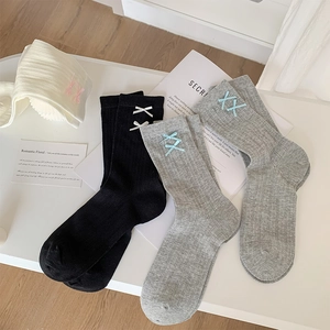Detail of ballet style bow socks in black, grey and white with vertical ribbed texture