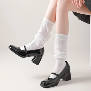 Close-up of black patent leather Mary Jane pumps with square toe and sturdy block heel