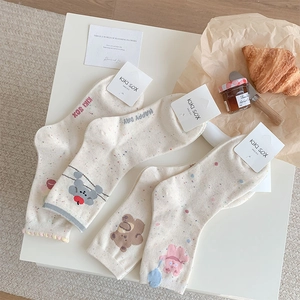 Detail of speckled mid-calf socks with cute cartoon bear patterns on a cozy background