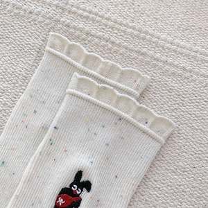 Detail of cream knit socks with colorful specks and cute rabbit embroidery decoration