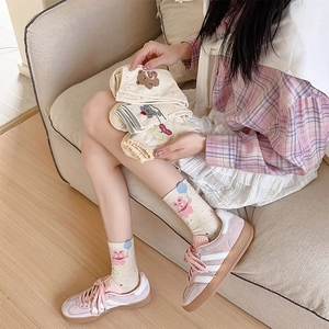 Close-up of cute bear pattern socks with heart polka dots and ruffled edge details