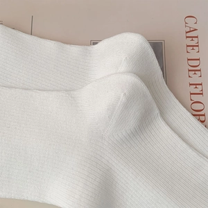 Gros plan sur la texture des chaussettes en tricot côtelé blanc de style épuré
