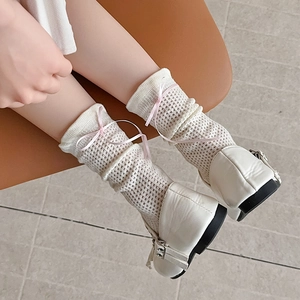Gros plan de chaussettes résille blanches avec nœuds roses et chaussures Mary Jane