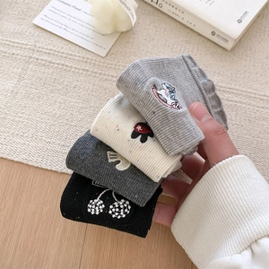 Close-up of four-color cotton knit socks with cartoon embroidery and ribbed cuffs