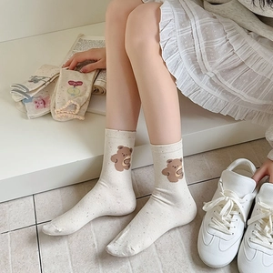 Close-up of off-white mid-calf cotton socks with cute bear print and ribbed cuffs