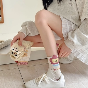 Detail of cute bear floral patterned socks with pink ruffled edges and point yarn texture