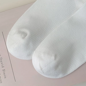 Vue macro de la pointe de chaussettes blanches côtelées avec couture fine et coton doux