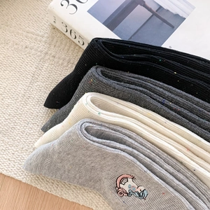 Detail of speckled yarn socks featuring cute cartoon embroidery in four pastel colors