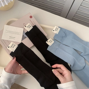 Détail de chaussettes en coton côtelé noir et bleu clair avec étiquette de cœur