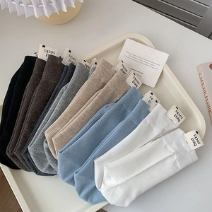 Détail de chaussettes en coton côtelé colorées avec étiquettes cœur minimalistes
