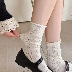 Detail of stretchy cream hollow mesh socks featuring elegant rolled edges and lace texture