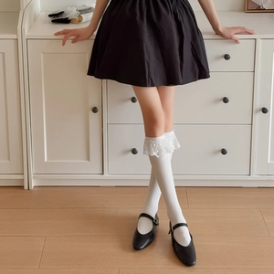 Détail de chaussettes en maille blanches avec bords en dentelle et motifs brodés
