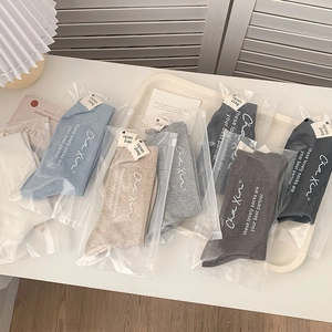 Détail de chaussettes mi-mollet côtelées en tons neutres avec pochette zippée de qualité
