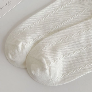 Detail of white mesh pointelle knit socks with wavy pattern for babies and kids