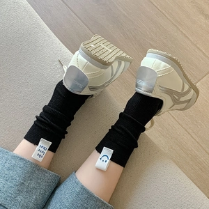 Close-up of black ribbed cotton socks with logo label paired with retro sneakers