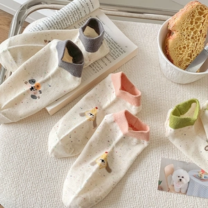 Detail of off-white polka dot socks with cute puppy embroidery and colorful ankle bands