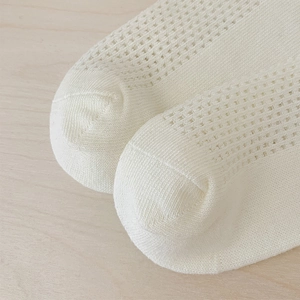 Gros plan sur la maille filet respirante et la pointe renforcée des chaussettes bébé