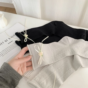 Detail of ribbon bow and handmade rose on textured knit mid-calf socks for women