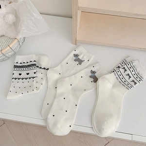 Detailed view of three mid-calf cotton socks with cute dog and bow tie patterns
